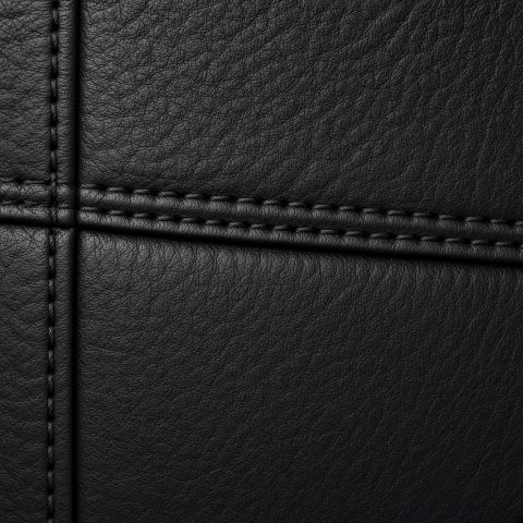 Black full-grain leather swatch with a stitched seam running through it